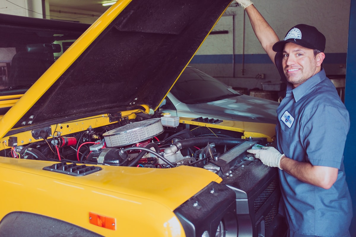 Profissional verificando o motor de um carro com o capô aberto